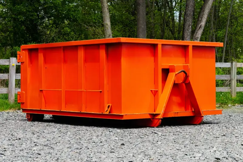 Small orange 10-yard roll-off dumpster on a gravel lot