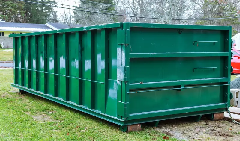 Green 30-yard roll-off dumpster on a residential lot